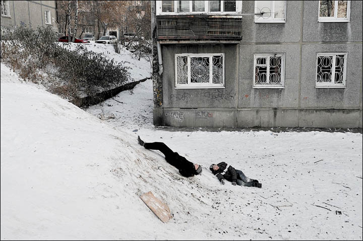 Two boys playing on the snow slope