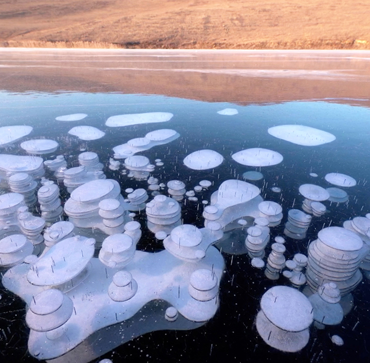 Beauty of frozen methane bubbles on the world’s deepest lake shown in stunning video