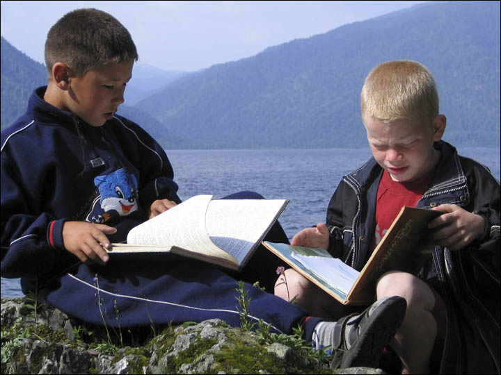 Boys reading the books on the Teletskoye lake